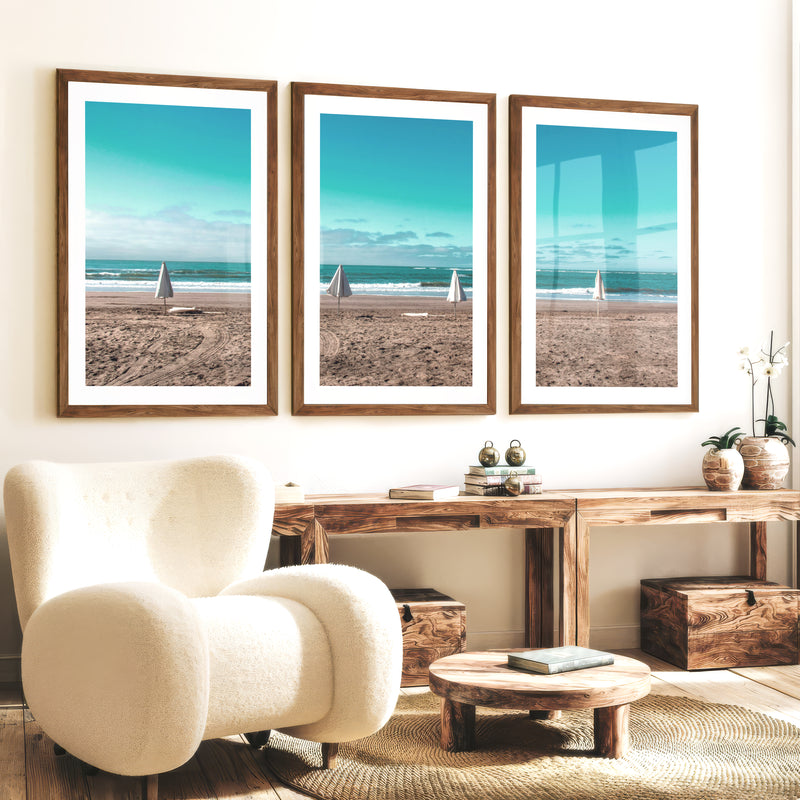 Closed Umbrellas beach pictures for wall beside Blue Surf - Dark Brown Framed Poster with White Border - Artworksets