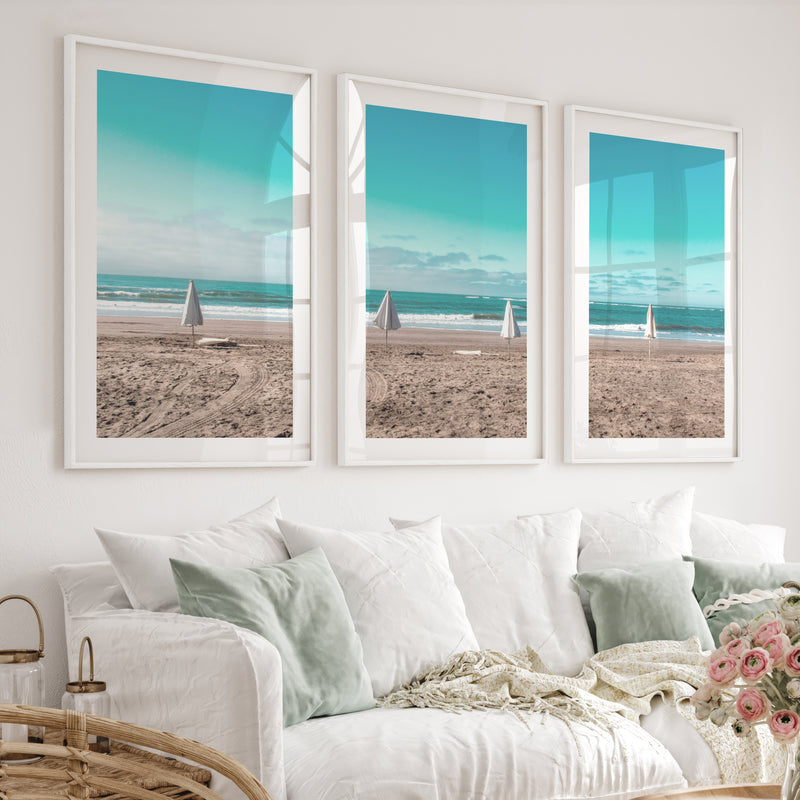 Closed Umbrellas beach pictures for wall beside Blue Surf - White Framed Poster with White Border - Artworksets